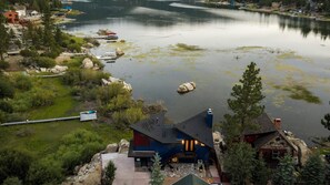 A lakeside property with a dock, boats, and a house with a dark roof. - Lakefront Boulder Bay Chalet with Hot Tub, A/C, Fire Pit & Panoramic Views (Big Bear Lake)