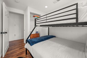 A bunk bed with a wooden frame and white bedding, a small wooden nightstand with a tissue box, and a door leading to another room. - Lakefront Boulder Bay Chalet with Hot Tub, A/C, Fire Pit & Panoramic Views (Big Bear Lake)