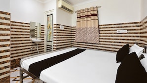 Een hotelkamer met een bed, een badkamer met een wastafel en een douche.