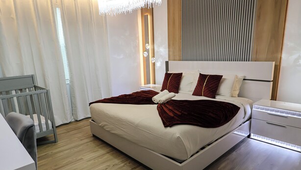 A modern bedroom with a large bed, a desk, and a chair. - Luxury Disney Manson - Newly renovated - Sleeps 30+ - Book today (Kissimmee)
