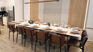 A modern dining area with a long table set for six, surrounded by six chairs. - Luxury Disney Manson - Newly renovated - Sleeps 30+ - Book today (Kissimmee)