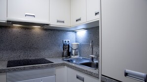 A compact kitchen with a built-in stove, a coffee maker, and a sink. - Vacation Studio 'Terraza A La Playa' with Wi-Fi (Las Palmas de Gran Canaria)