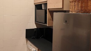 A compact kitchen with a washing machine, a microwave, and a refrigerator. - Apartment at the foot of the legendary Matterhorn in the Cervina–Zermatt area. (Breuil-Cervinia)