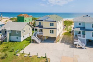 A beachfront property with multiple houses, a central building with a porch, and a clear view of the ocean. - Spectacular Sunrises, Pool, Hot Tub, Theater Room, Office, SN9317 (Nags Head)