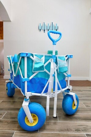 Ein Kinderwagen mit blau-weißer Farbgebung, ausgestattet mit einem am vorderen Teil angebrachten Griff und großen Rädern.