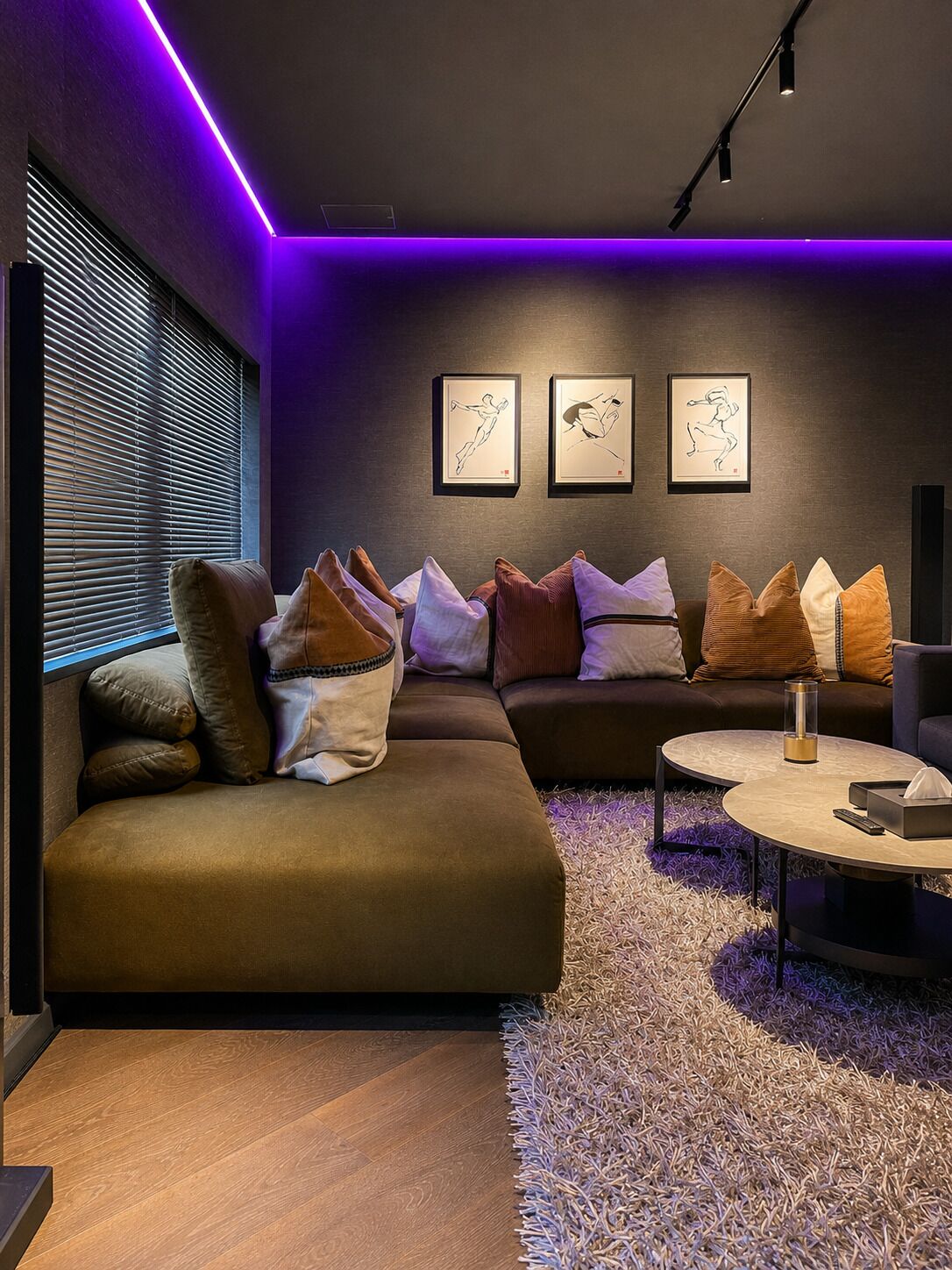A modern living room with a sectional sofa, a round coffee table, and three framed artworks on the wall.