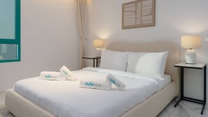 A hotel room with a bed, two bedside tables, a window, and a wall-mounted artwork. - Stunning Open-Concept 3 Bedrooms (Dubai)