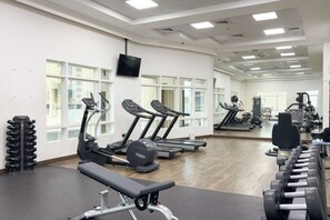 A gym with treadmills, elliptical machines, and weight benches. - Stunning Open-Concept 3 Bedrooms (Dubai)