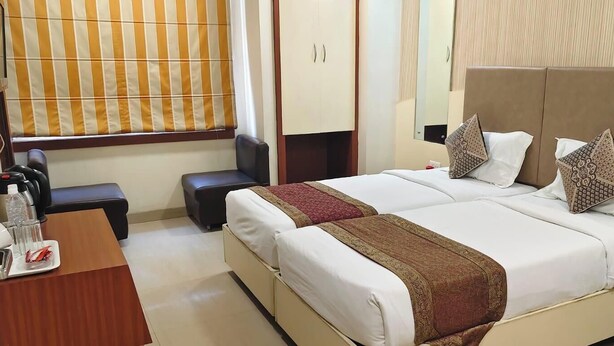 Une chambre d’hôtel comprenant un lit, un bureau, une chaise et une armoire.