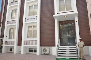 A hotel entrance with a sign reading 'Miravana,' a staircase leading up to the entrance, and a person standing at the bottom of the stairs. - NIRVANA HOTEL (Varanasi)