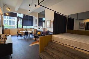 A modern bedroom with a bed, a desk, and a dining area. - IMCT - Astoria Central Home 2 (Budapest)