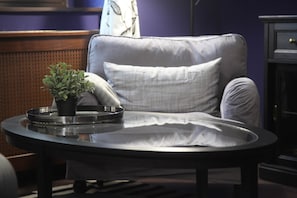 A modern living room with a round glass table, a grey upholstered armchair, and a small potted plant. - IMCT - Ambassador Apartment (Budapest)
