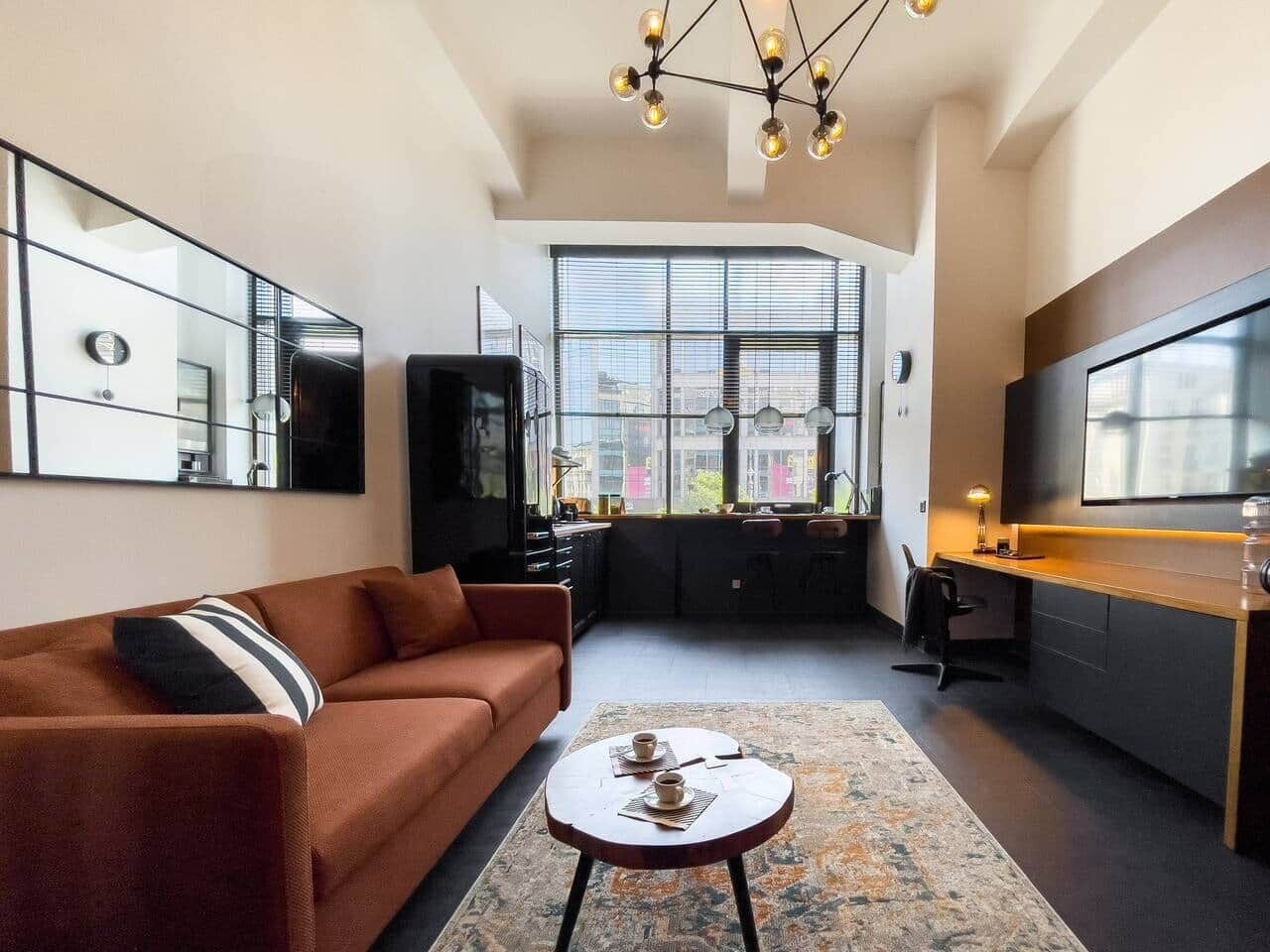Ein modernes Wohnzimmer mit einer Couch, einem Couchtisch und einer Küchenzeile mit Esstisch und Stühlen.