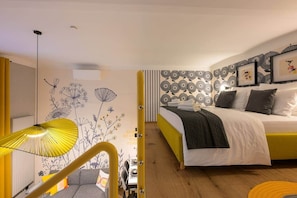 A modern bedroom with a bed, a yellow lamp, and a wall with floral patterns. - Dockhouse Soho 4 (Budapest)