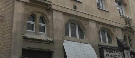 A multi-story building with a sign for 'RUHAZATIL SZAKUZLET' and a visible storefront.
