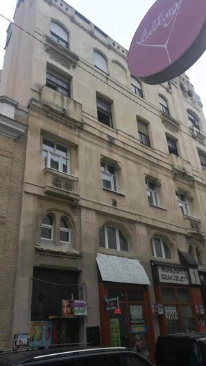 A multi-story building with a sign for 'RUHAZATIL SZAKUZLET' and a visible storefront. - IMCT - Beliz Apartment 2 in the City Center (Budapest)