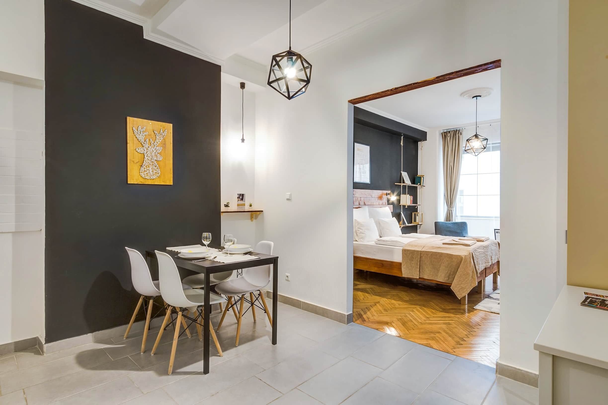Un appartement moderne comprenant un coin repas, une chambre et un espace de vie.