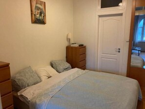 A bedroom with a bed, a dresser, a nightstand, and a door. - IMCT - Danube View Apartment (Budapest)