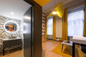 A modern bathroom with a round mirror, a sink, and a shower area. - IMCT - Dockhouse Soho 2 (Budapest)
