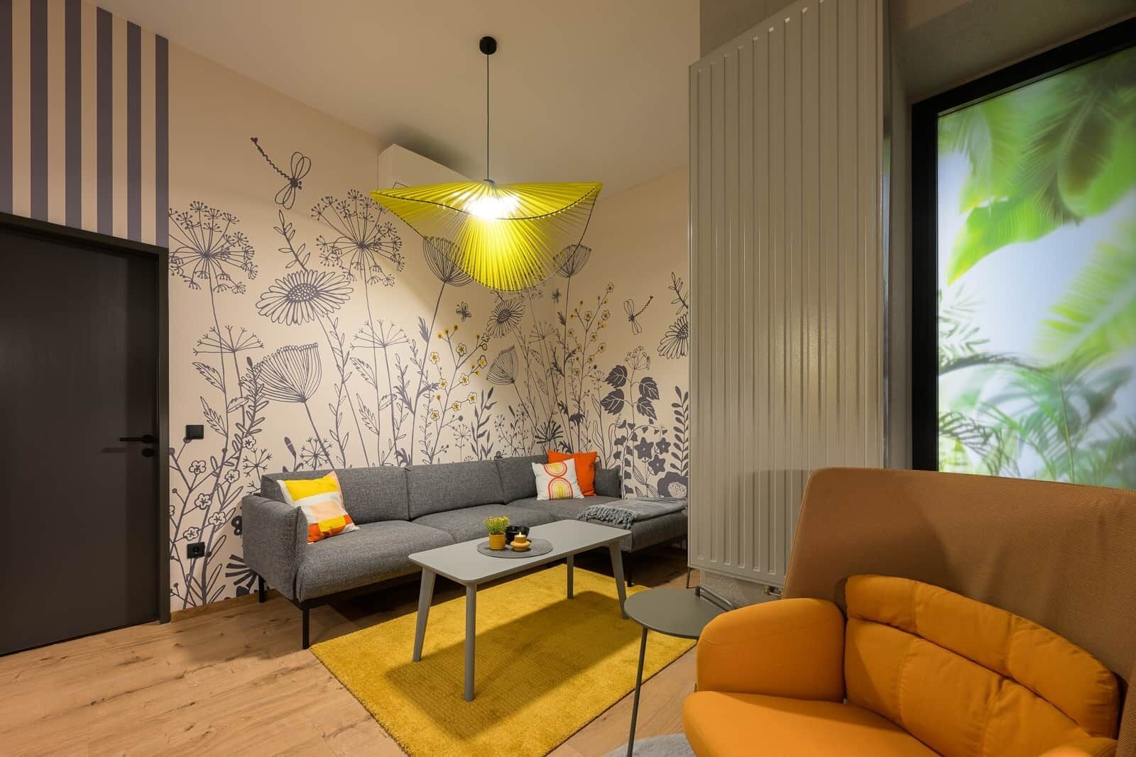 A modern living room with a sofa, coffee table, and an orange armchair.