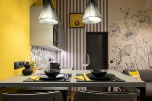 A modern dining area with a striped wall, a black and yellow color scheme, and a minimalist design. - IMCT - Dockhouse Soho 1 (Budapest)