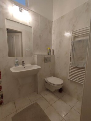 A bathroom with a white sink, a toilet, a mirror, and a towel rack. - IMCT - Elegance in the Heart (Budapest)