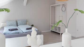 Een moderne slaapkamer met een bed, een witte garderobe en een hanglamp.