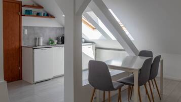 Een moderne keuken met witte kasten, een aanrecht en een dakraam erboven.