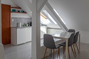Une cuisine moderne avec des meubles blancs, un plan de travail et une lucarne au-dessus.