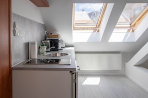 Une cuisine moderne dotée de fenêtres de toit, d’un four encastré et d’un radiateur.