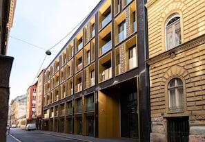A multi-story building with a modern facade, large windows, and a ground-level entrance. - IMCT - FullBloom in the center (Budapest)