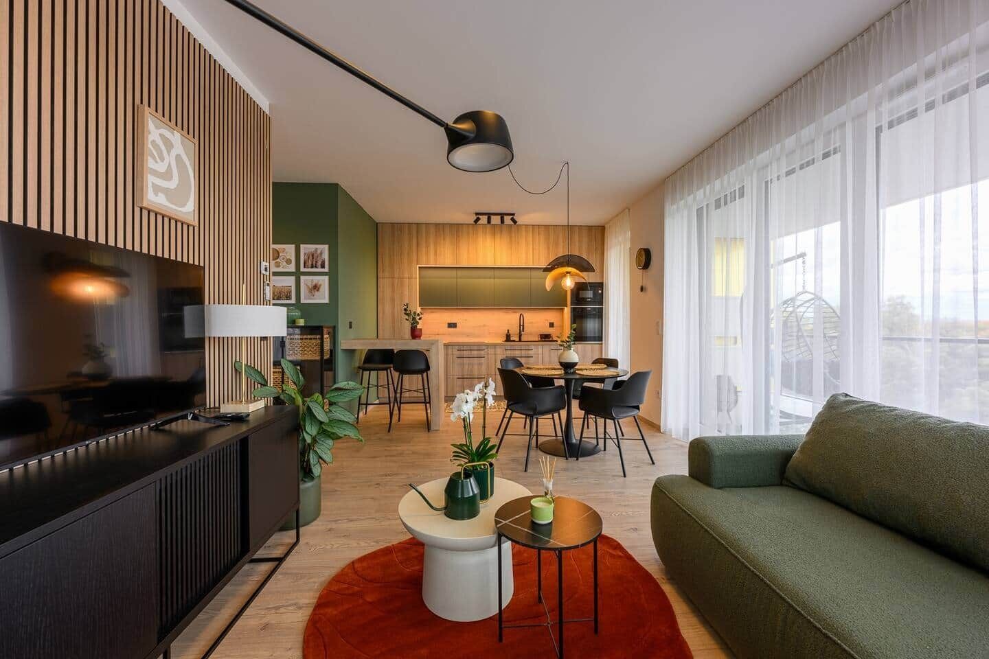 A modern living space with a kitchen, dining area, and a sofa.