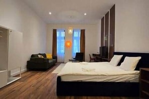 A bedroom with a bed, a sofa, a desk, and a television. - IMCT - Masa Apartman 3 Budapest (Budapest)