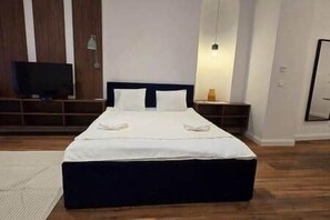 A bedroom with a large bed, a television, and a bedside table. - IMCT - Masa Apartman 3 Budapest (Budapest)