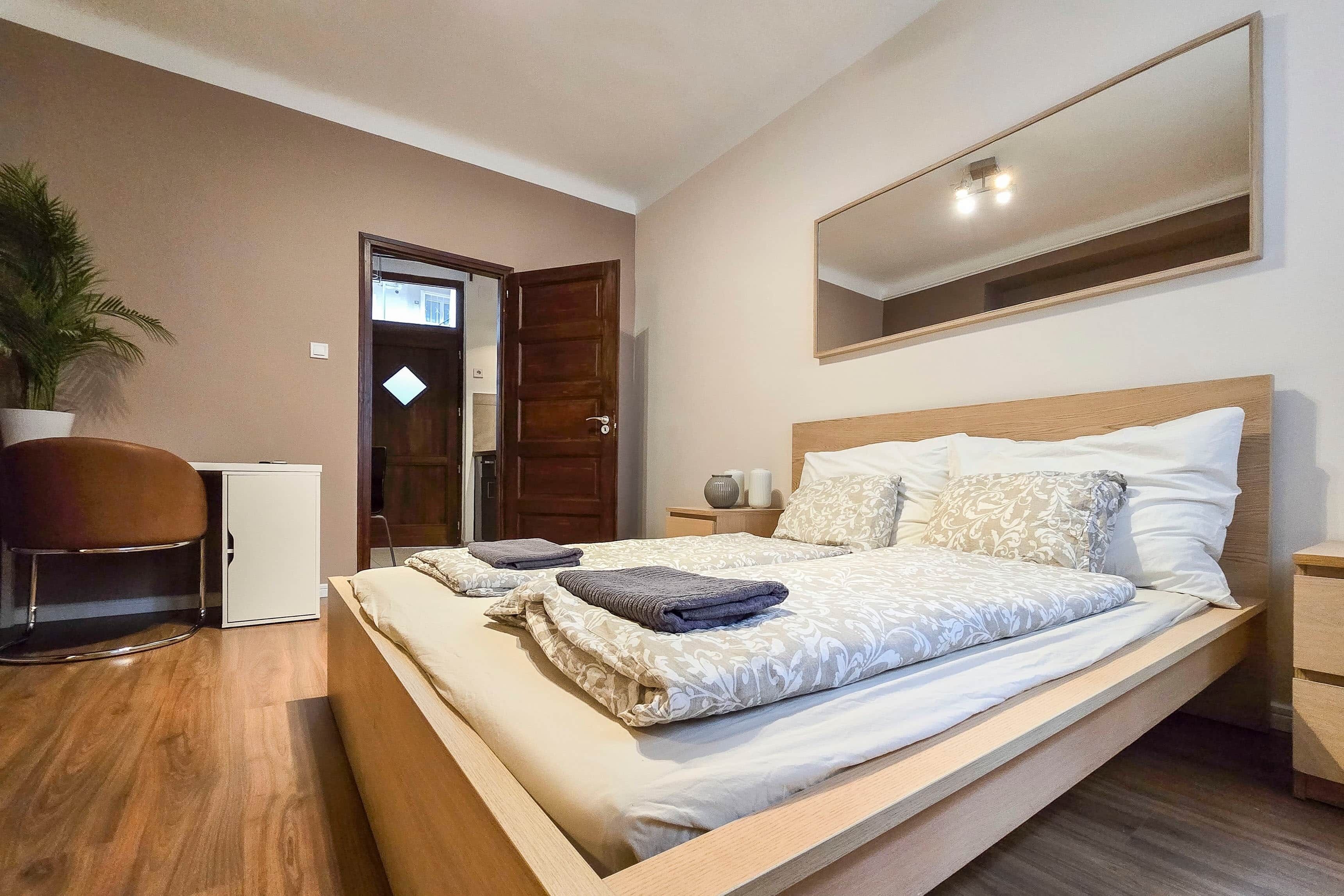 Une chambre d’hôtel comprenant un lit, des tables de chevet, un bureau et une chaise.