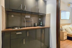 A modern kitchen with a built-in stove, a sink, and a drying rack. - IMCT - New City Life Apartment (Budapest)