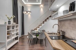 Eine moderne Küche mit Essbereich, einer Treppe und einer Kochinsel.