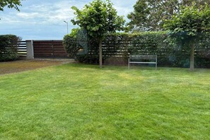 A well-maintained grassy area with a bench and a fence. - LB - Balaton Nova Apartment-Beachfront (Siófok)
