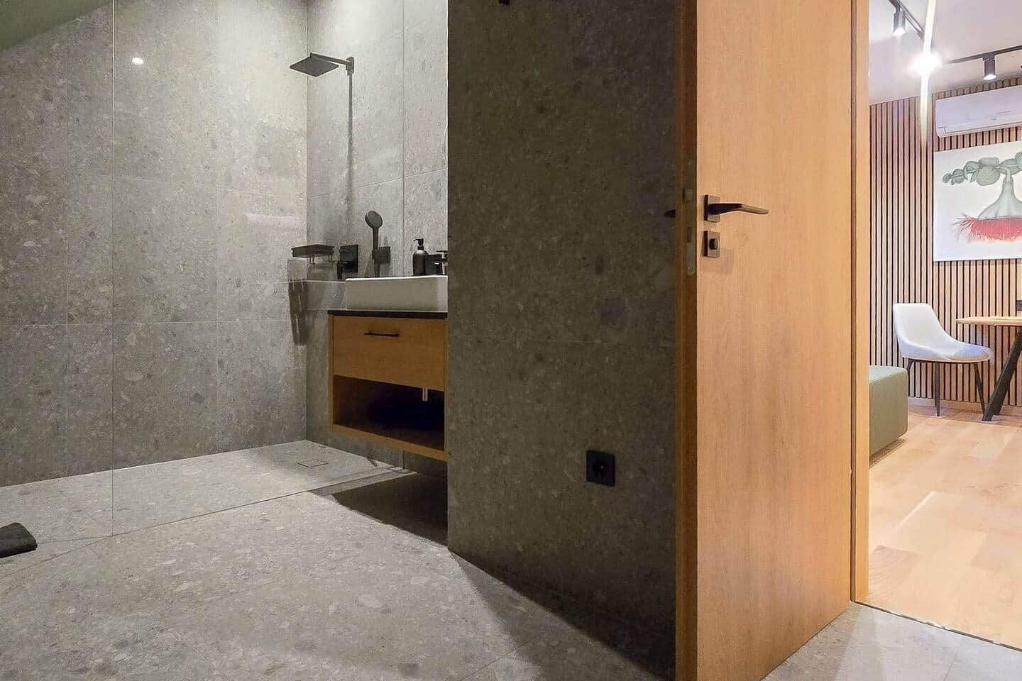 Une salle de bain moderne avec une douche, un lavabo et un meuble en bois.