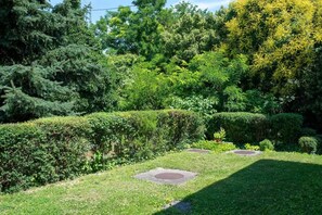 A well-maintained garden with manicured hedges, a variety of trees, and a clear pathway. - LB - Mecseki Apartman (Balatonkenese)