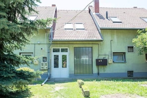 A building with a tiled roof, a front door, and a mailbox. - LB - Mecseki Apartman (Balatonkenese)