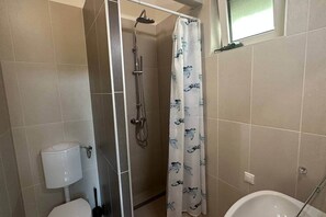 Ein Badezimmer mit Dusche, Toilette und Badewanne.