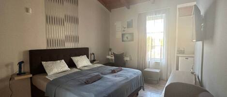 A bedroom with a bed, bedside tables, a desk, and a chair.