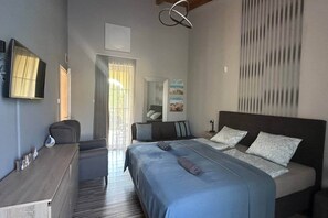 Ein Schlafzimmer mit Bett, Nachttischen, einem Schreibtisch, einem Spiegel und einem Fenster mit Vorhängen.