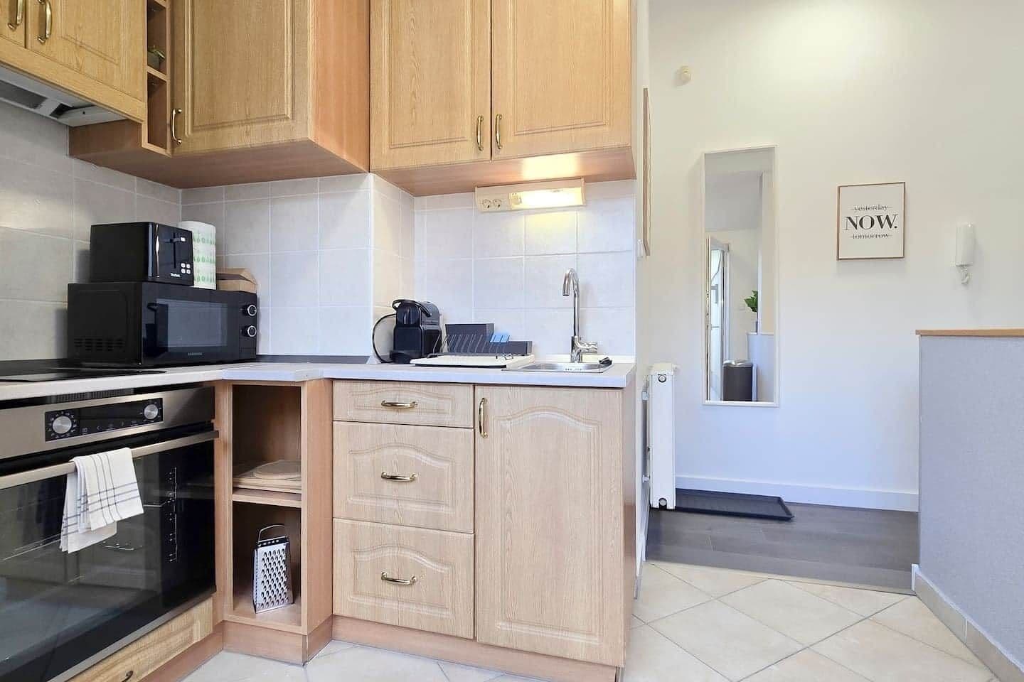 A compact kitchen with a microwave, stove, and a coffee maker.