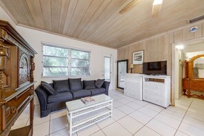 A living room with a sofa, coffee table, and a television on a stand.