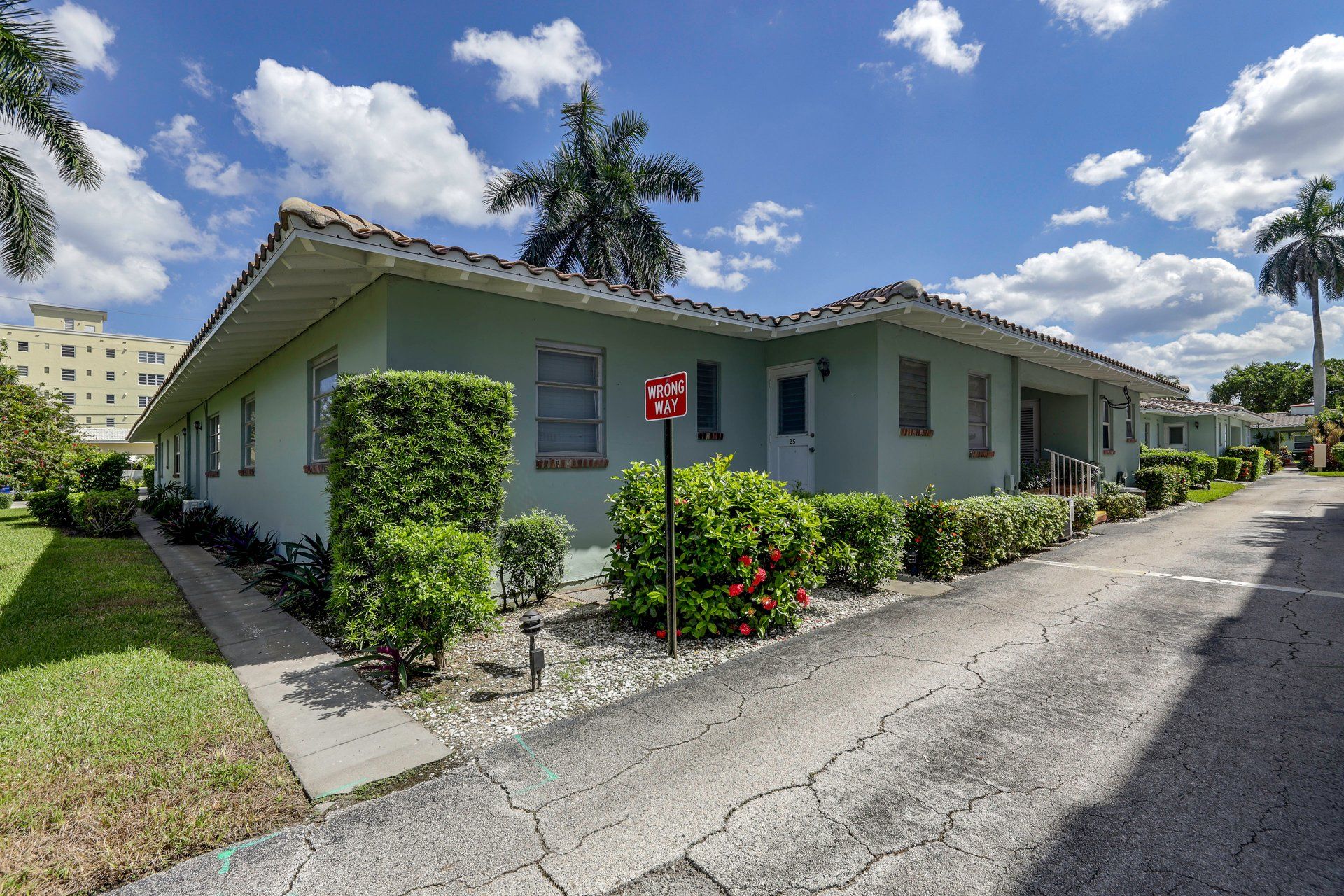A single-story house with a flat roof, a front porch, and a driveway.
