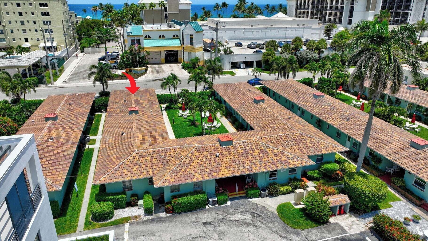 Un hotel con varias unidades, un estacionamiento y vista al océano.