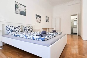 A bedroom with a bed, bedside tables, and a wardrobe. - MidTerm - CityCenter67 Apartment (Budapest)