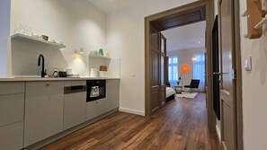Eine moderne Küche mit Geschirrspüler, Kaffeemaschine und einer Glasvitrine.